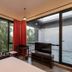 Triose Boutique Hotel Lonavala room with large windows, red curtains and a TV, overlooking greenery