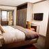 Hotel Bristol Verbier bedroom in Bagnes with double bed, balcony view and wall-mounted TV