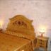 Masseria Magli Resort in Martina Franca room with ornate carved bed and matching bedside tables