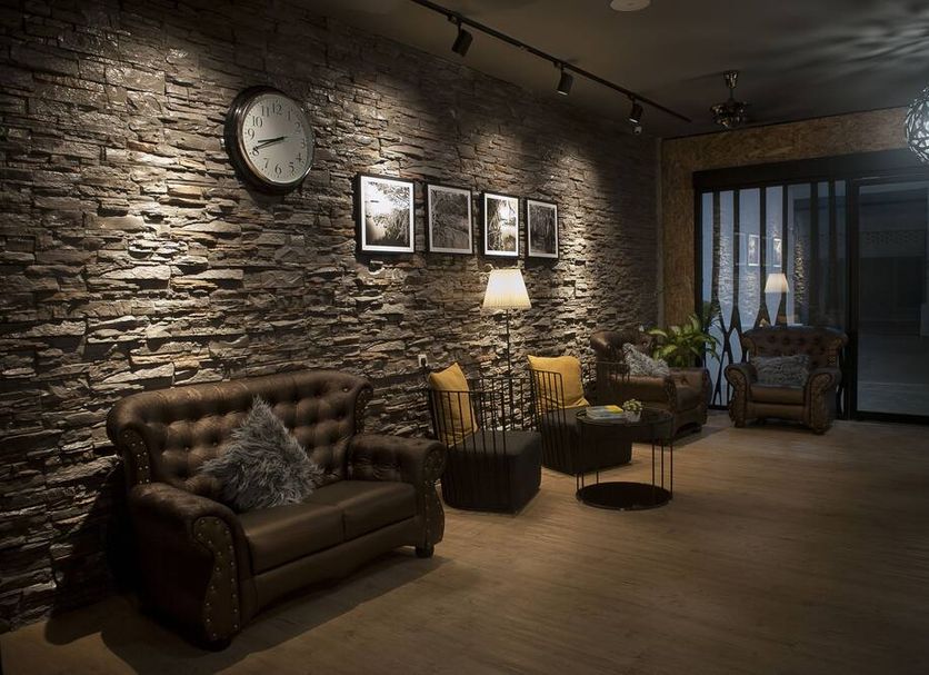 Big Banana Hotel in Sungai Petani lounge with stone wall, leather sofa, clock and patio door