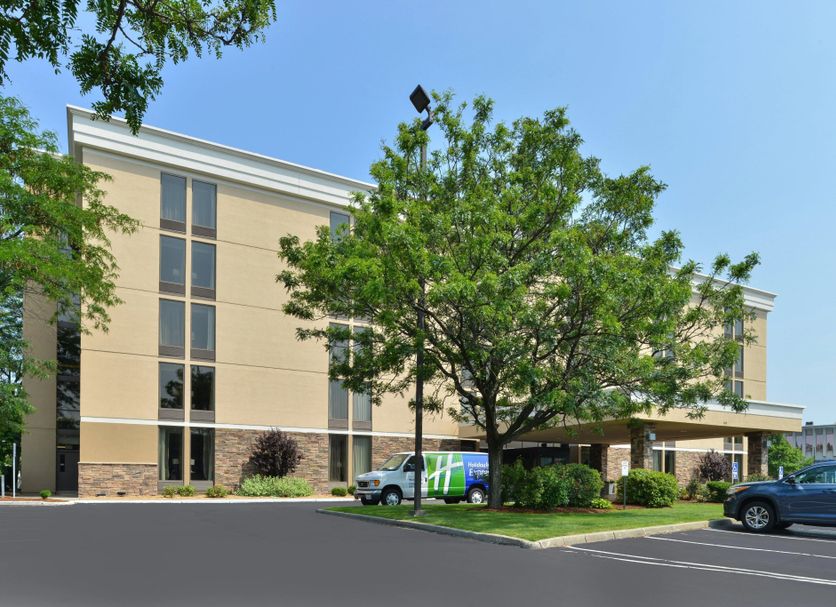 Envision Hotel Worcester Downtown exterior in Worcester with trees, parking lot, and parked vehicles