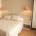 Hotel La Ronda in Castro-Urdiales guest room with double bed, bedside lamps, and wood flooring