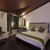 Hotel Dip Palace Darjeeling guest room with king bed, TV, desk and window with curtains