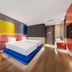 Yiting Huicheng Hotel Xiamen room with two twin beds, colorful accent walls and wood flooring