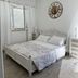 Female Resort, San Felice Circeo: bright white guest room with bed, window, and wall clock