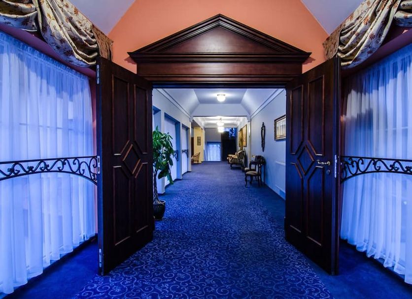 Hotel Wellness & Spa Nowy Dwór in Świlcza, blue-carpeted hallway with dark wood double doors