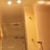 Westside Studio Apartments in Armidale bathroom with glass shower, mirror cabinet and ceiling lights
