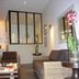 Hôtel En Ville lounge seating area in Aix-en-Provence with wicker sofa, coffee table and mirror