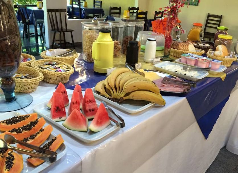 Breakfast buffet at Hotel da Ilha in Ilhabela with fruit, pastries, juice, and coffee