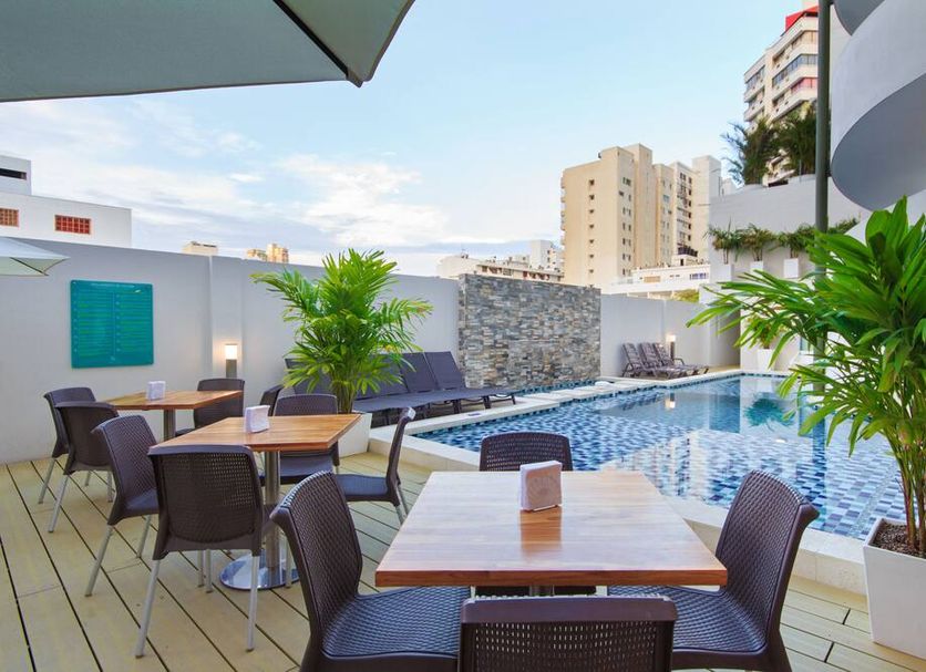 Del Mar Hotel Santa Marta rooftop poolside terrace with tables, chairs and city views
