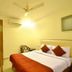 Hotel Golden Inn Chandigarh room with double bed, wall-mounted TV, desk and ceiling fan