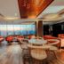 The Peninsula Chittagong Limited lounge with city skyline views and orange seating in Chittagong