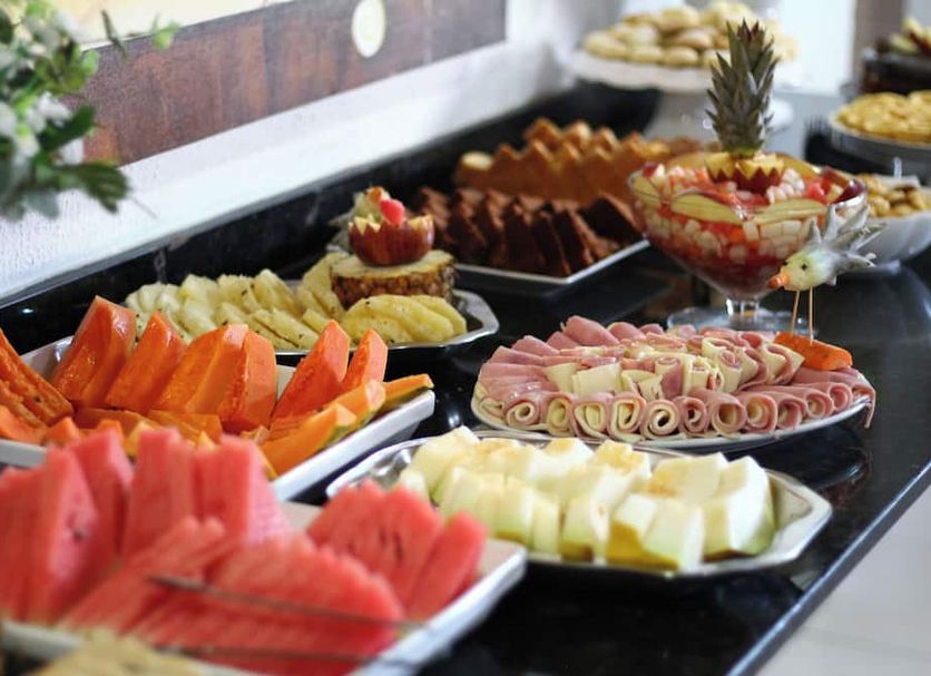 Hotel Aracaju Express in Aracaju buffet table with sliced fruit, pastries, and cold appetizers