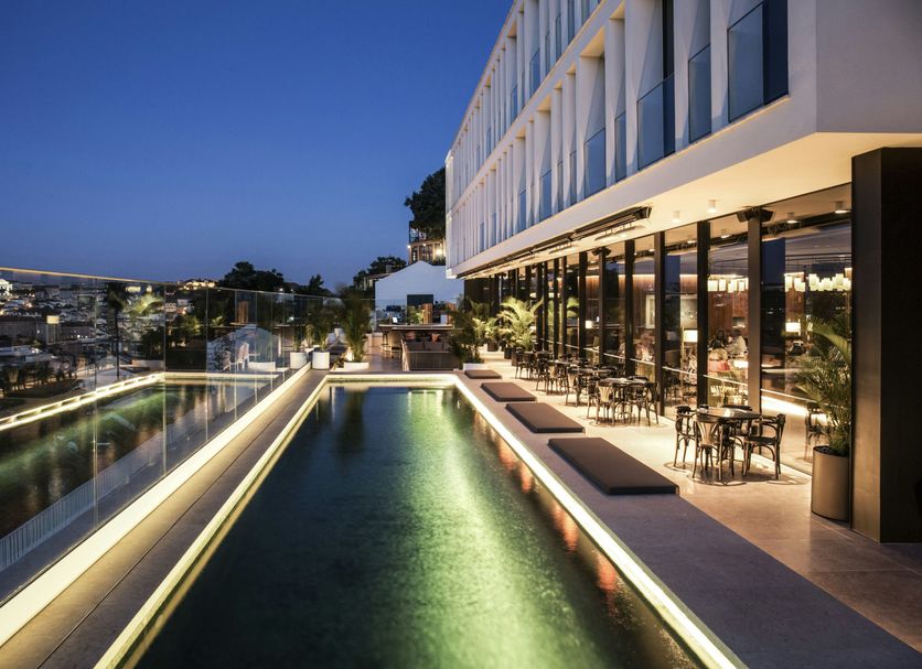 Memmo Principe Real Lisbon rooftop pool terrace with glass railing and city views at dusk