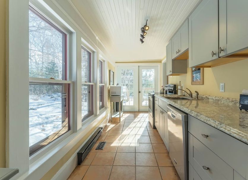 Dominion Hill Country Inn in Bocabec kitchen with granite counters, windows, and patio doors