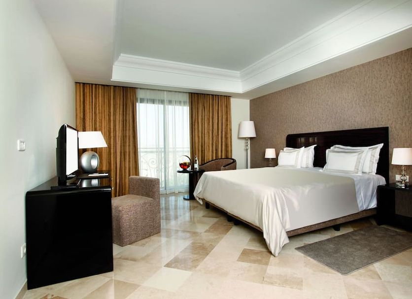 Concorde Paris, Tunis: guest room with king bed, desk, lamps, and balcony doors