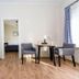 Kurort Stara Wedzarnia in Gdansk: bright room with TV, dining table, chairs, and blue accent wall