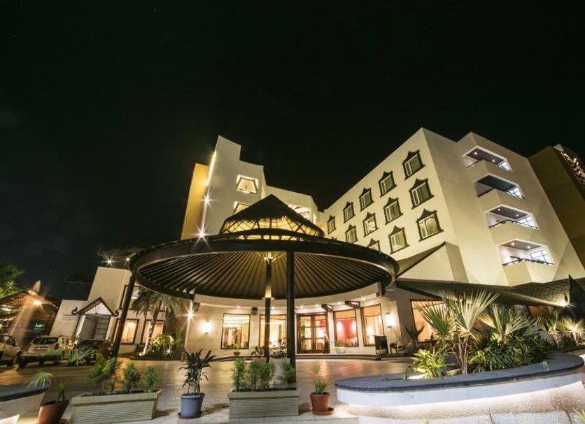 Rudraksh Club & Resorts in Ujjain, lit hotel entrance with landscaped courtyard and circular canopy