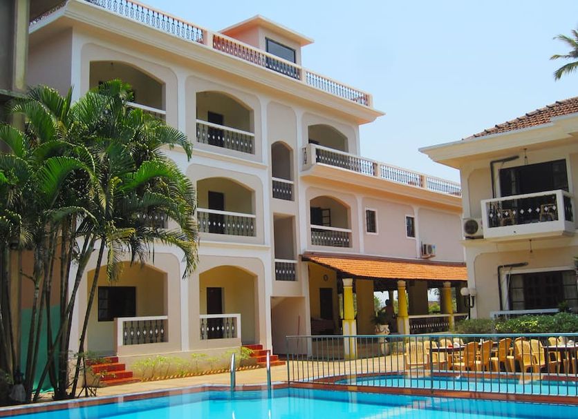 Riverside Regency Resort in Baga with courtyard pool and palm trees beside white resort buildings