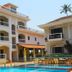 Riverside Regency Resort in Baga with courtyard pool and palm trees beside white resort buildings