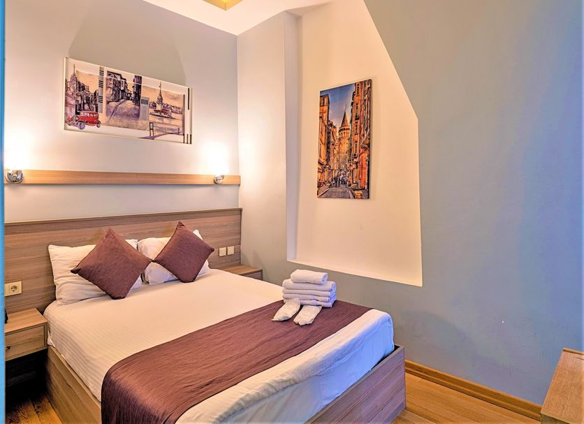 Ragip Pasha Apartments Istanbul bedroom with double bed, wall art, and folded towels