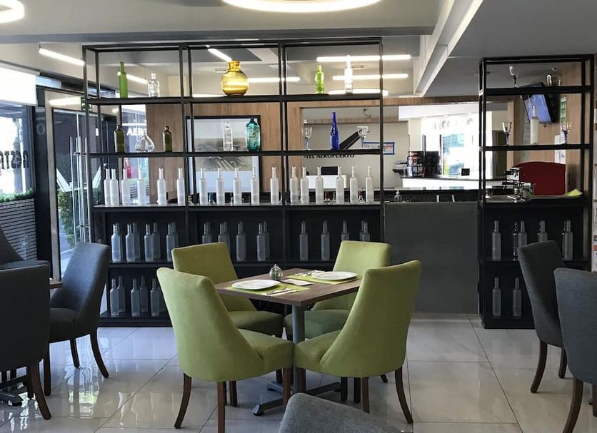 Hotel Aeropuerto Mexico City lounge bar with green chairs and bottle display