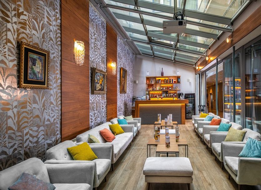 Charm Hotel Budapest lounge with glass سقف, long bar, and colorful sofas in Budapest