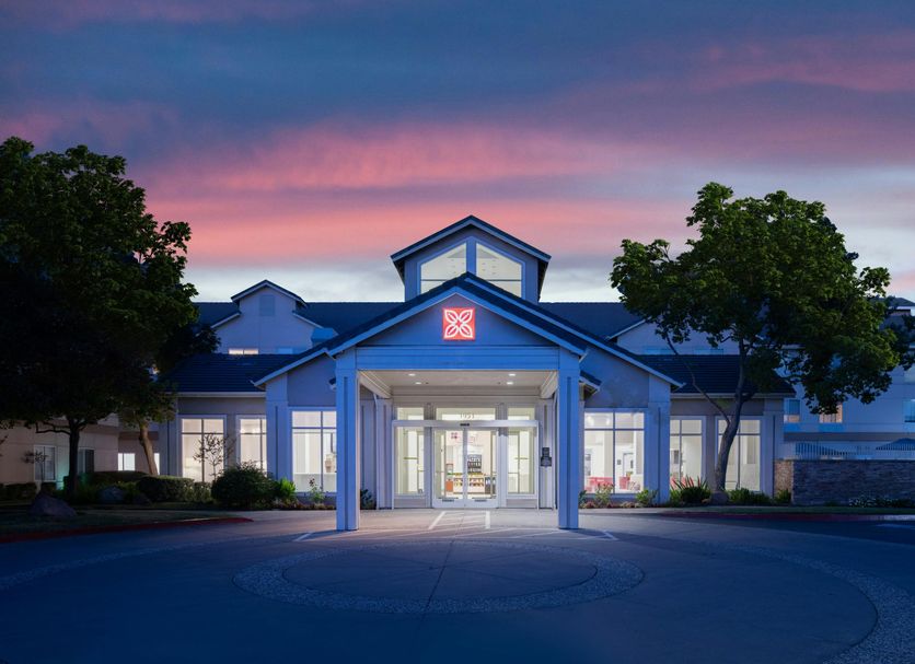 Hilton Garden Inn Roseville exterior at dusk with illuminated entrance and pink sky