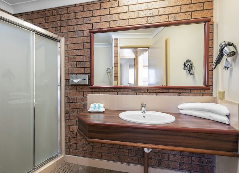 Bomaderry Motor Inn in Nowra bathroom with shower, sink vanity and wall mirror