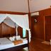 Sayang Beach Resort in Ko Lanta room with four-poster bed, wood-paneled walls and vanity area
