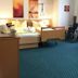 Gesundheitshotel Das Bad Peterstal room with twin bed, wheelchair, table and chairs in Bad Peterstal-Griesbach