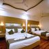 Grand Legacy Beacon, Dehradun room with two double beds, wood-paneled headboards and ceiling fans