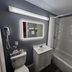 Howard Johnson by Wyndham Woodstock NB bathroom with tub-shower, vanity, mirror and towel rack