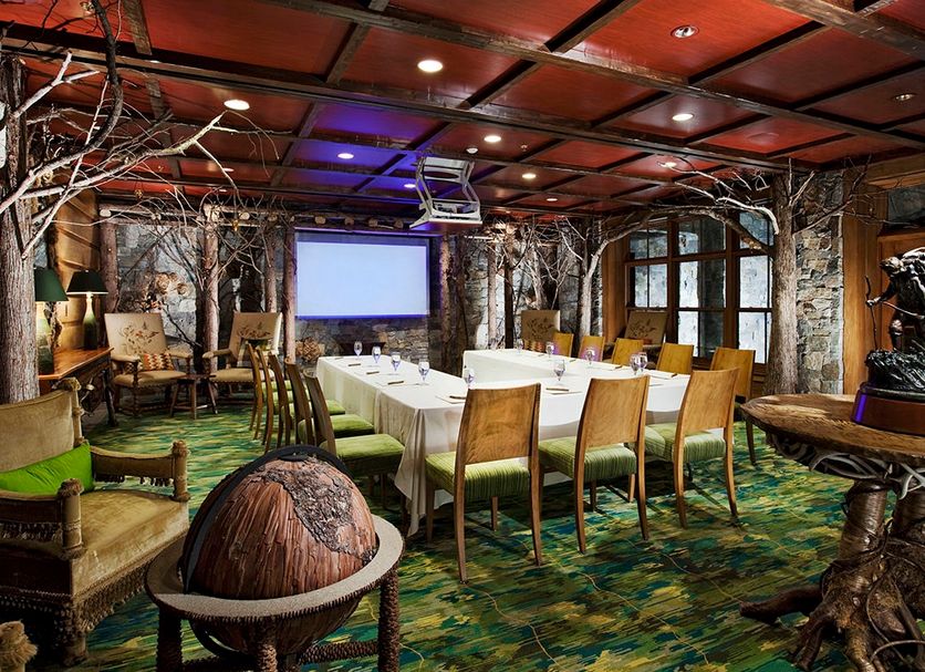 Lake Placid Lodge meeting room with conference table, projector screen, rustic decor and forest-style accents