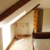 Au Pied Levé in Trévron: attic bedroom with sloped ceiling, skylight, bed, and clothing rack