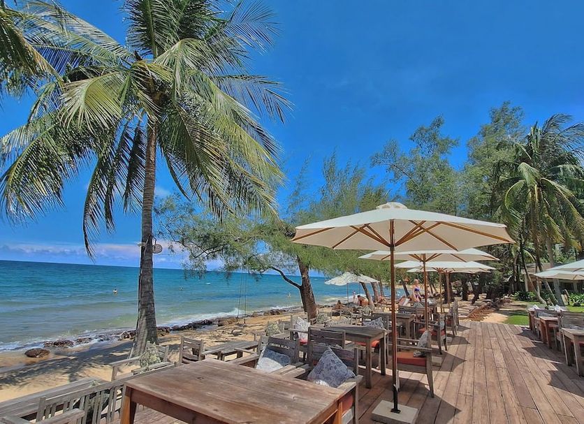 Ancarine Beach Resort, Phu Quoc: beachfront deck with tables, umbrellas, palm trees and sea view