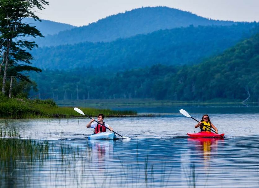 Garnet Hill Lodge in North River with guests kayaking on a peaceful mountain lake