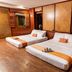 Dang Derm Khaosan Bangkok guest room with two twin beds, wood-paneled walls and windows