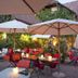 Outdoor terrace at Landgasthof Bären in Madiswil with umbrellas, red chairs and tables