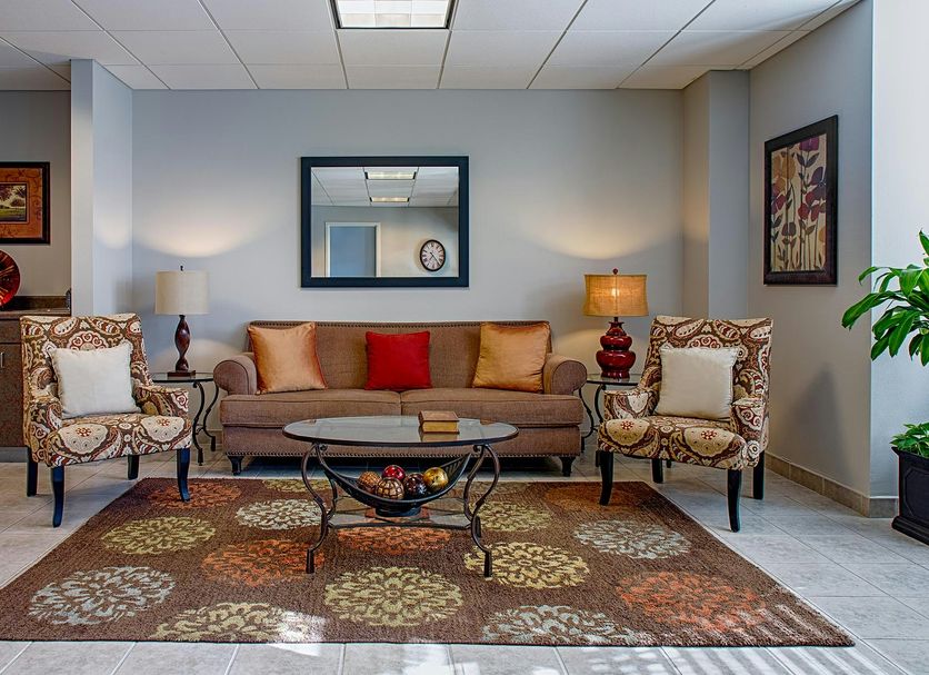 Federal City Inn & Suites lobby seating area with sofa, armchairs, coffee table and rug in New Orleans