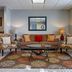 Federal City Inn & Suites lobby seating area with sofa, armchairs, coffee table and rug in New Orleans