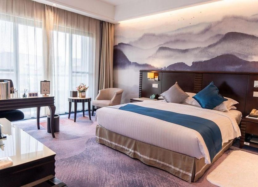 Xiang Ming Luxury Airport Hotel, Huangshan guest room with mountain mural and twin bedside lamps