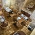 New Hôtel Gare Du Nord in Paris dining area with wicker chairs and set tables in a stone-walled room