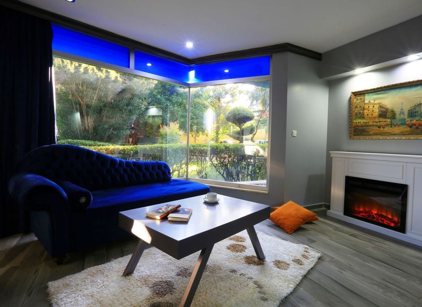 Çetinel Otel in Adana living room with corner garden view, fireplace, sofa and coffee table