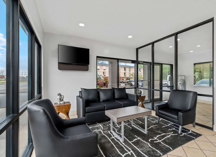 Quality Inn & Suites Biloxi - Ocean Springs lobby seating area with black chairs, sofa and city view