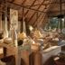 Victoria Falls River Lodge lounge with woven seating, river views, and thatched wood-beam سق? interior