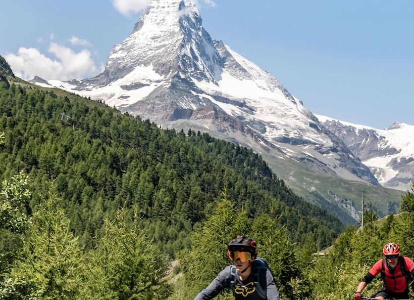 Hotel Pollux in Zermatt with Matterhorn mountain view and cyclists in the foreground