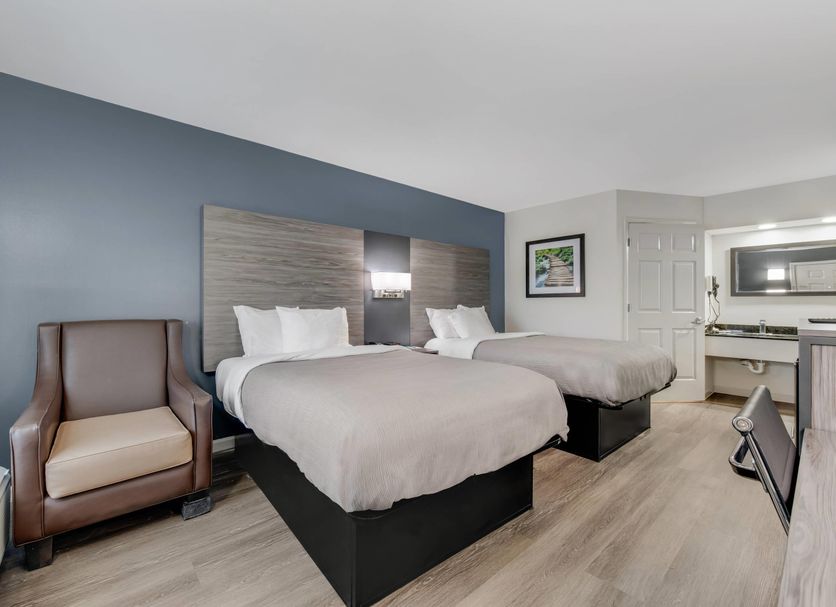 Quality Inn Laurinburg guest room with two beds, armchair, desk and kitchenette area