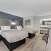 Quality Inn Laurinburg guest room with two beds, armchair, desk and kitchenette area