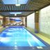 Diplomat Hotel Astana indoor pool with lounge chairs and mural wall